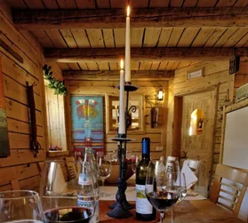 Representative hotel space: A rustic wooden dining room with a long table set with wine glasses.