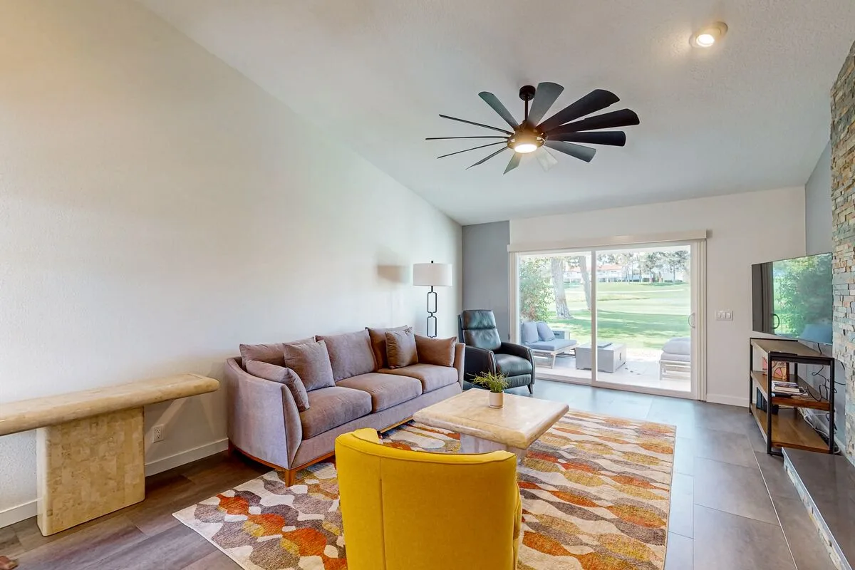 A living room with seating around a coffee table and sliding glass doors.