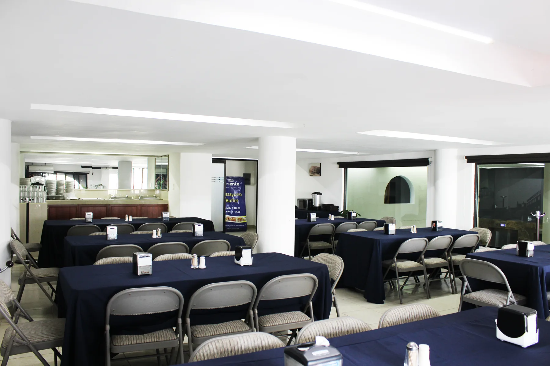 Representative hotel space: A dining area with tables covered in dark cloths and folding chairs.