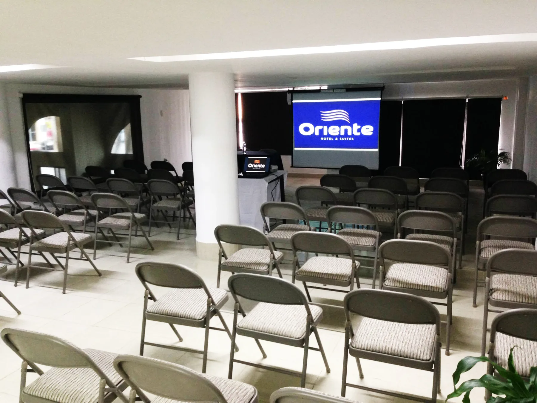 Representative hotel space: A meeting room with rows of folding chairs facing a screen.