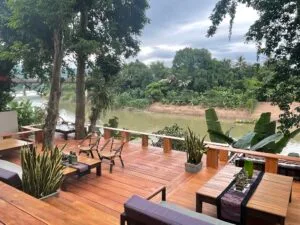Representative hotel space: A wooden outdoor deck with seating overlooks a river and green landscape.