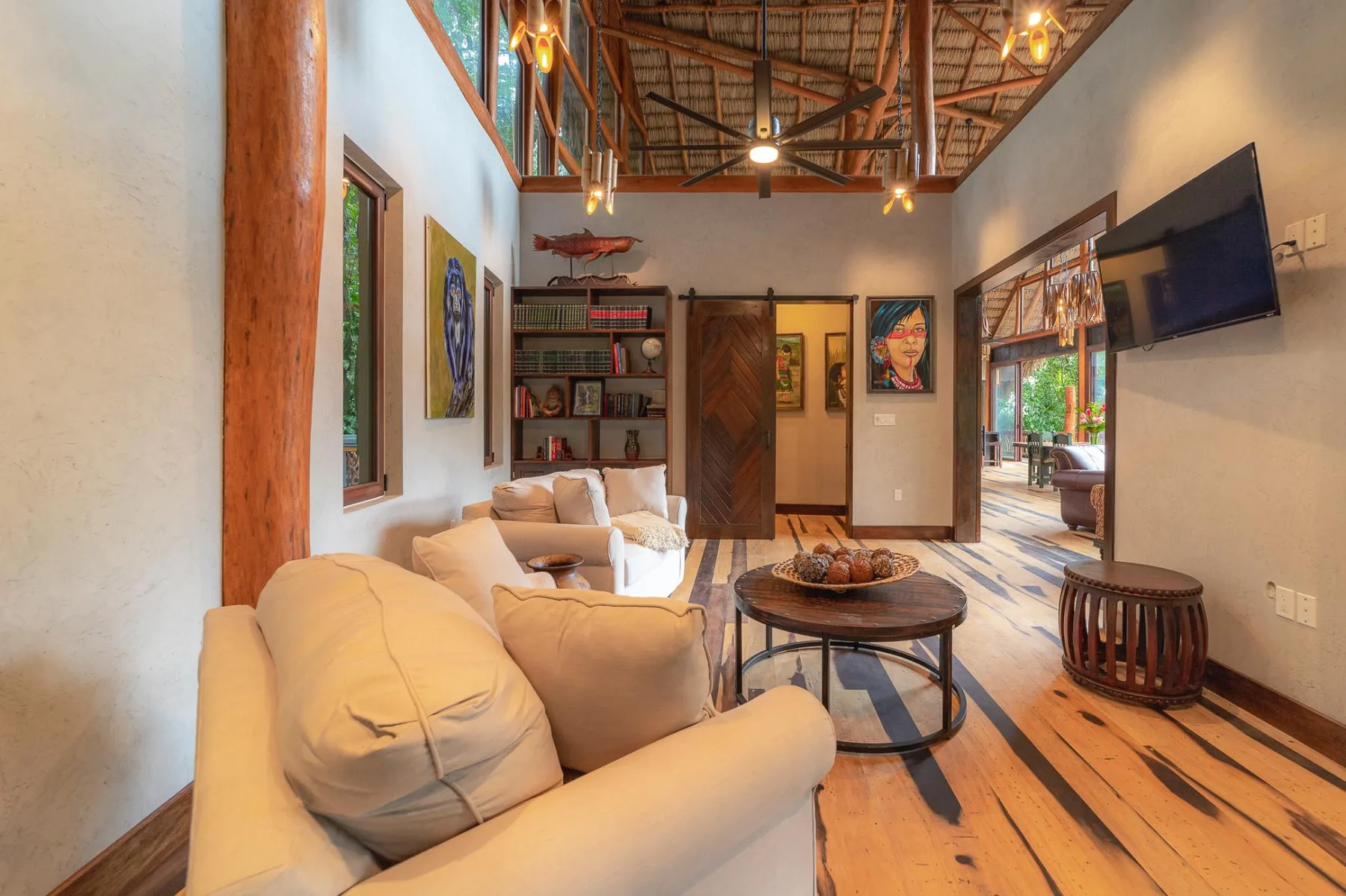 A living room with cushioned seating, a round coffee table, and exposed ceiling beams.