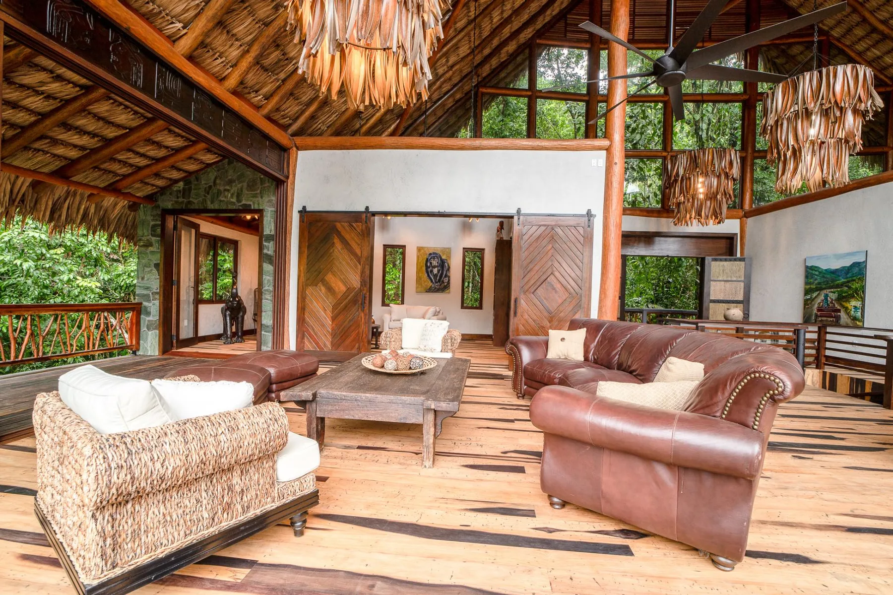 A spacious living room with leather seating beneath a high timber ceiling.