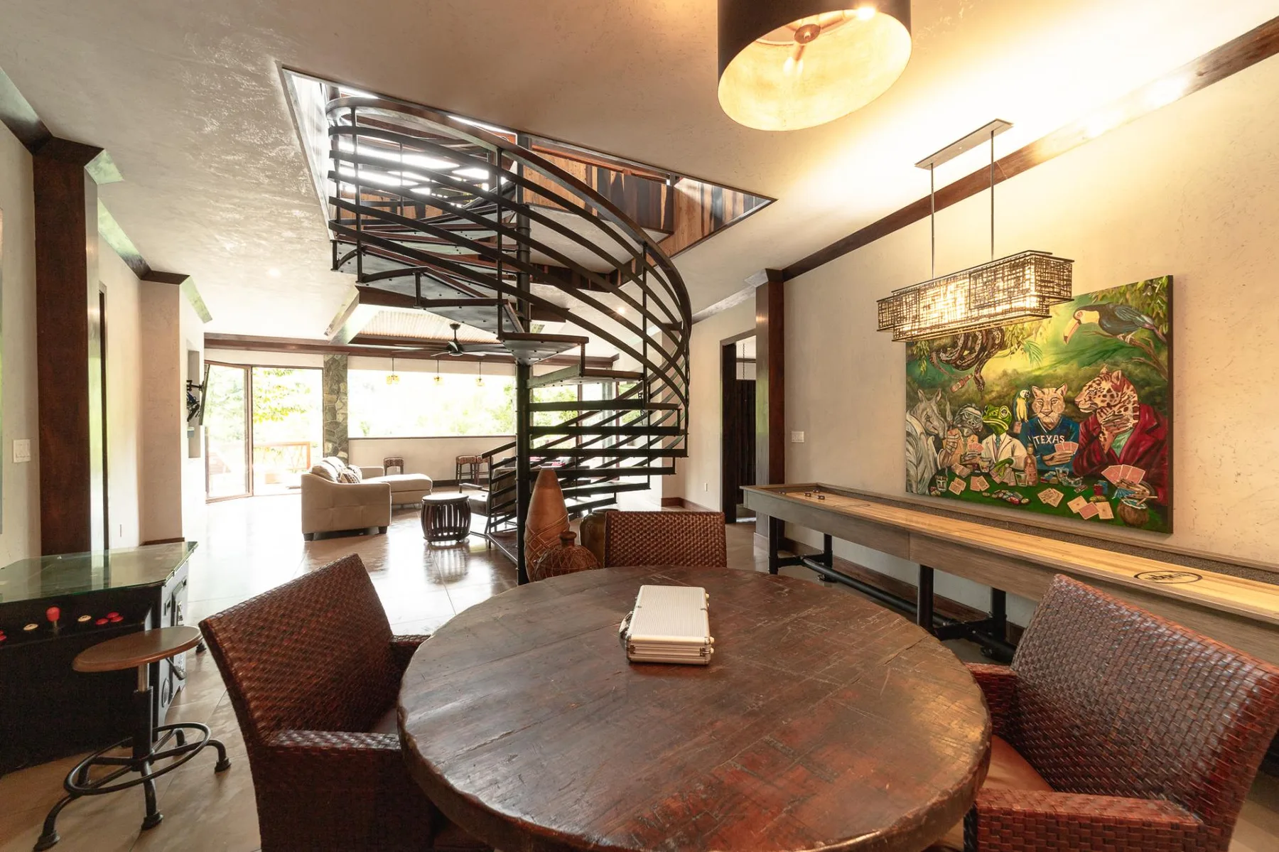 A dining area with a round table and a curved spiral staircase.
