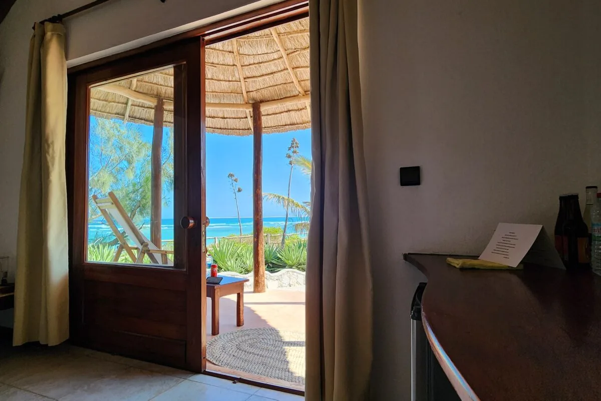 Una puerta abierta da a un patio sombreado y al mar.