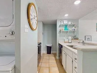 Un baño luminoso con un tocador largo y suelo de baldosas.