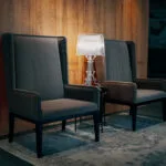 Espacio representativo del hotel: Dos sillas están junto a una mesa pequeña en una habitación con paredes revestidas de madera.