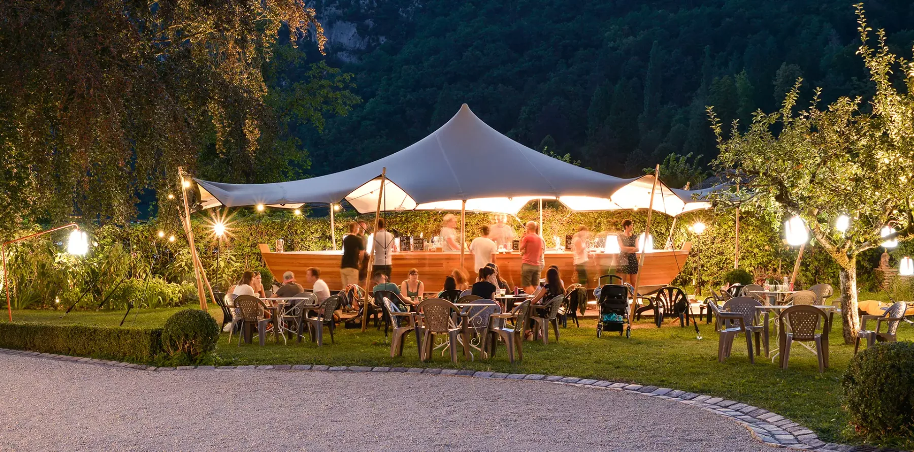 Espacio representativo del hotel: Un comedor al aire libre con mesas bajo una gran carpa iluminada.