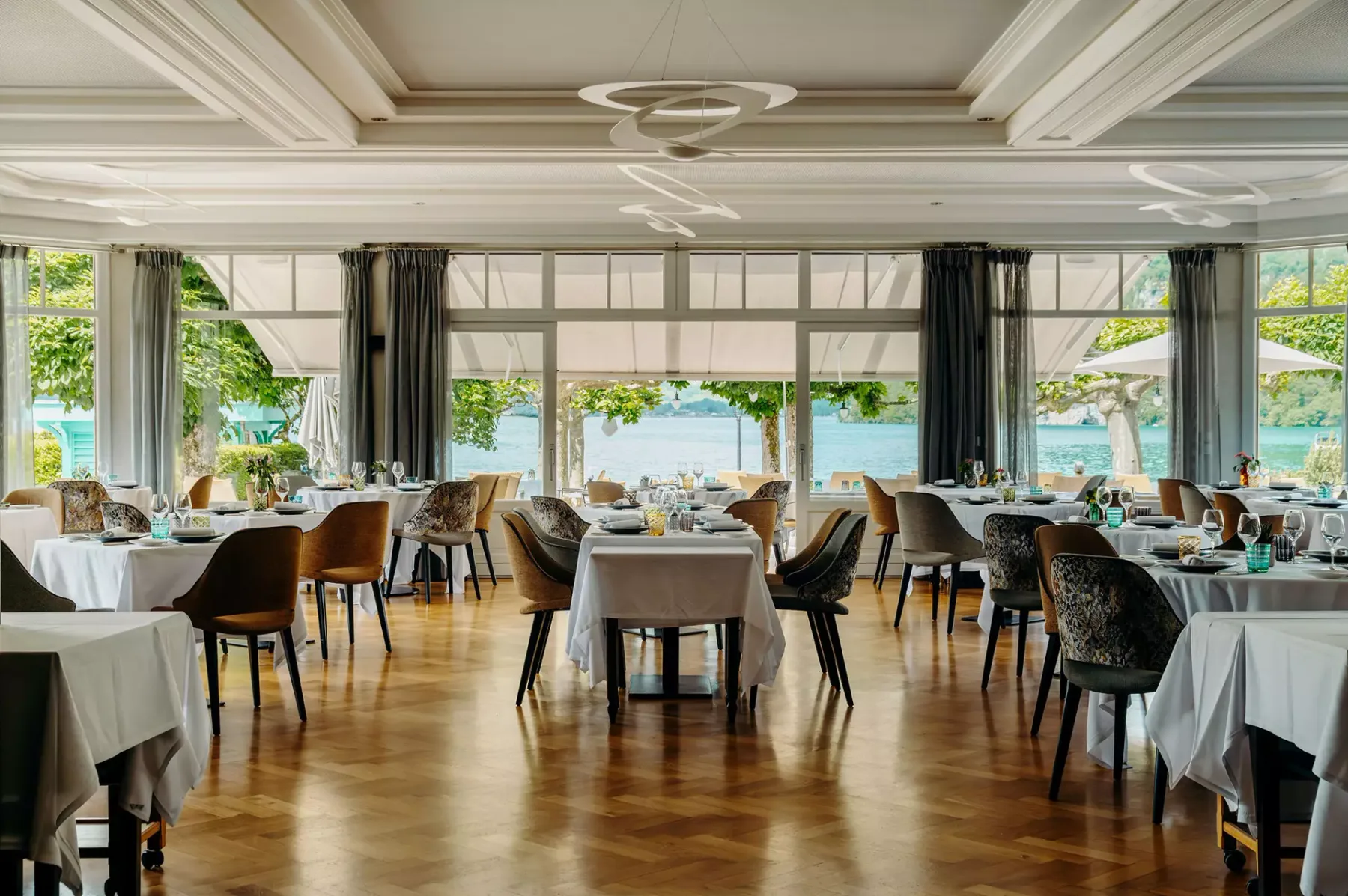 Espacio representativo del hotel: Un comedor luminoso con mesas y asientos junto a grandes ventanales.