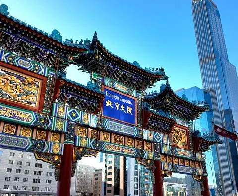 Representative hotel space: An ornate traditional Chinese gateway stands among modern city buildings.