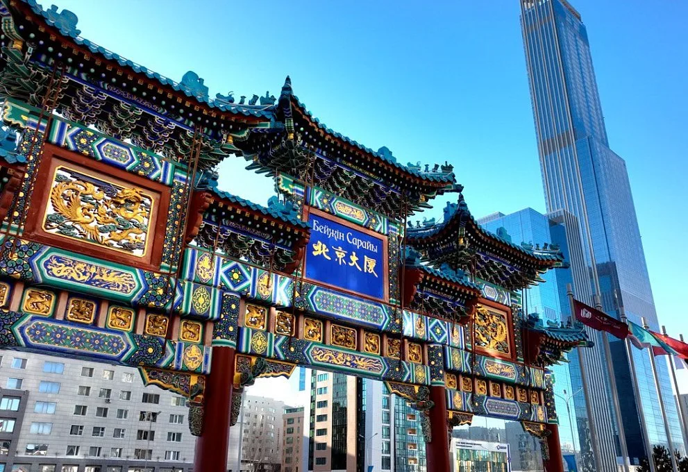 Representative hotel space: An ornate Chinese-style gateway stands beside modern high-rise buildings.