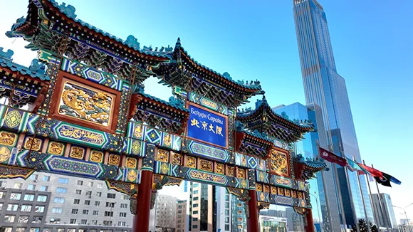 Representative hotel space: An ornate Chinese-style gateway stands beside modern high-rise buildings.