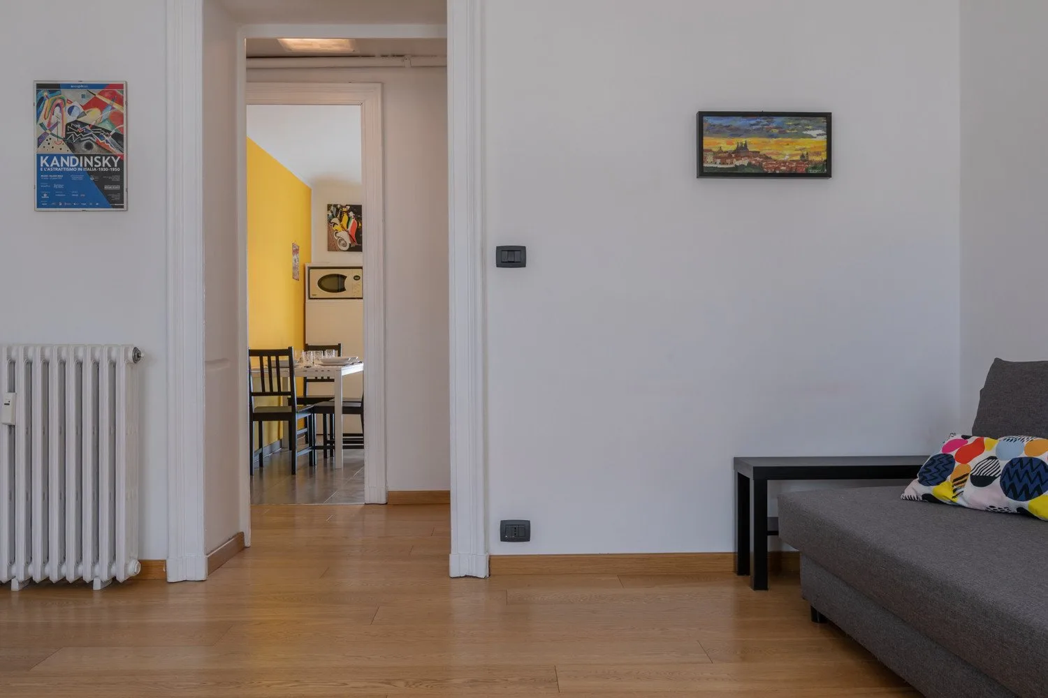 Una sala de estar con asientos junto a una puerta abierta hacia el comedor.