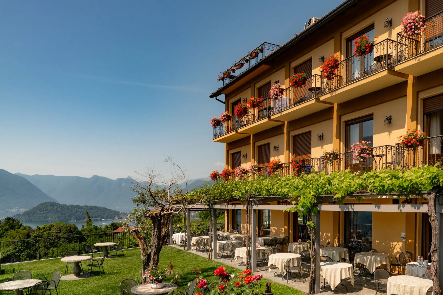 Representative hotel space: Hotel building with flower-lined balconies overlooking a garden and mountain landscape.