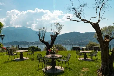 Representative hotel space: A grassy outdoor seating area overlooks a lake and distant mountains.