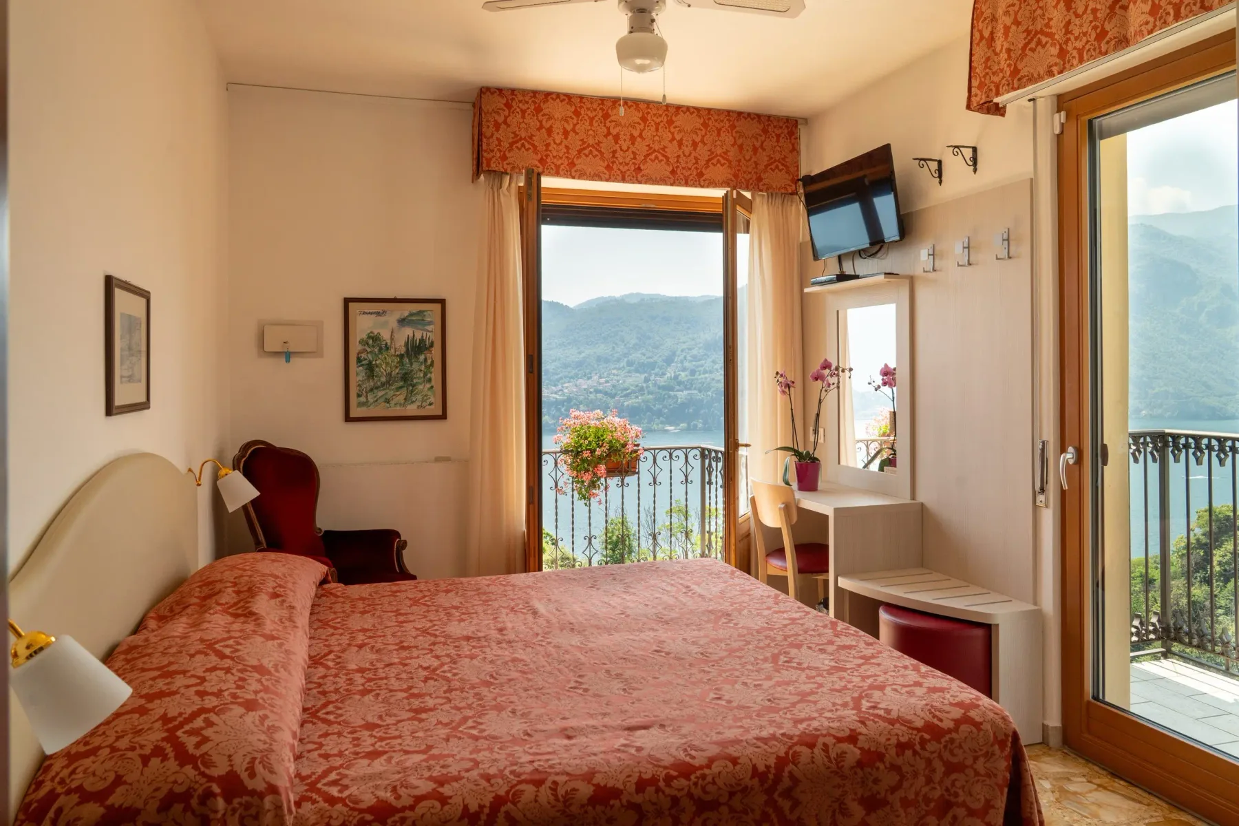 Representative hotel space: A bedroom with a patterned bedspread and balcony doors overlooking the mountains.