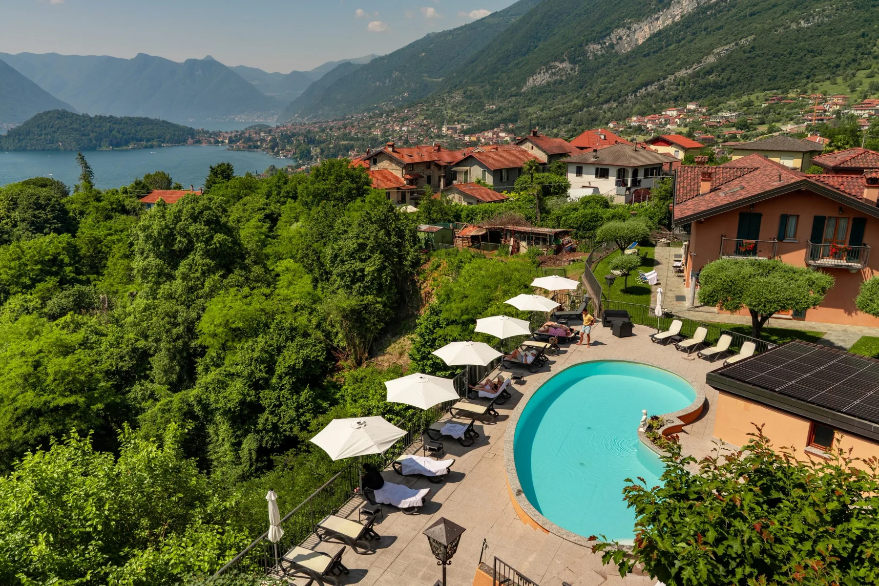 Representative hotel space: A hillside pool area overlooks a lakeside town and surrounding mountains.