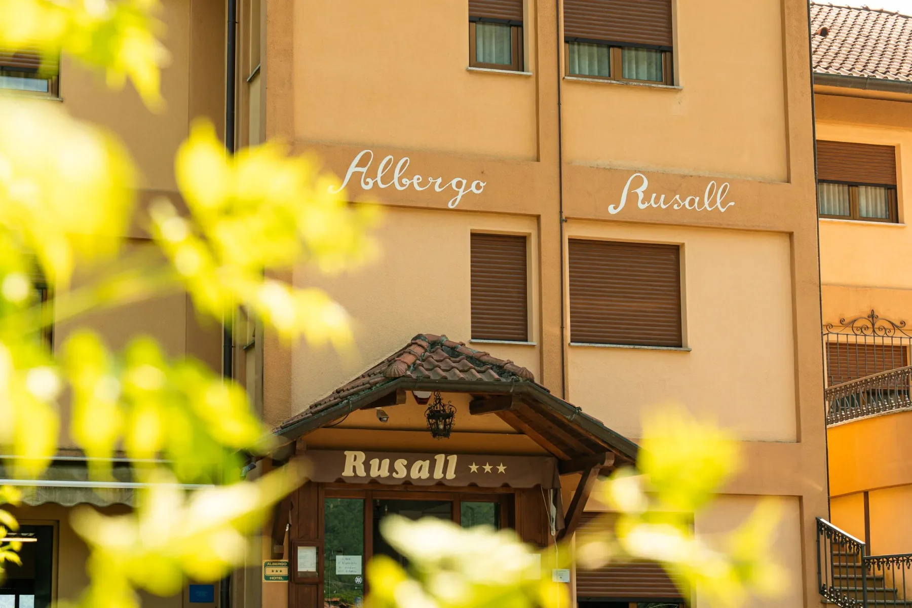 Representative hotel space: Hotel entrance beneath a tiled canopy, with the name Rusall above the doorway.