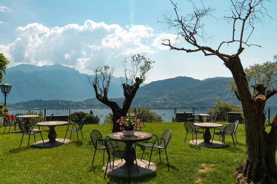 Representative hotel space: Outdoor dining area with tables and seating overlooking a mountain landscape.