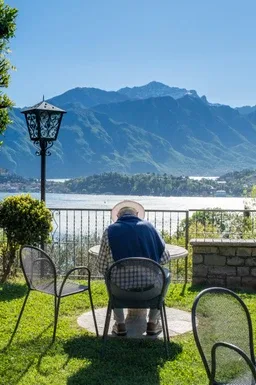 Representative hotel space: A garden seating area overlooks a lake and mountain range.