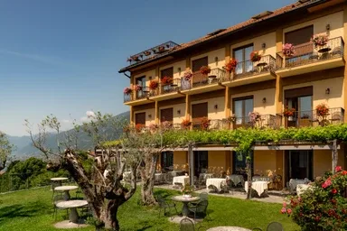 Representative hotel space: A hotel building with balconies overlooks a garden seating area.