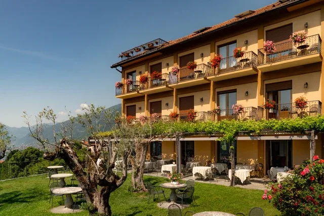Representative hotel space: A hotel building with flower-lined balconies overlooks a garden dining area.