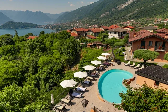Representative hotel space: An outdoor pool and lounge area overlook a lakeside village and surrounding mountains.