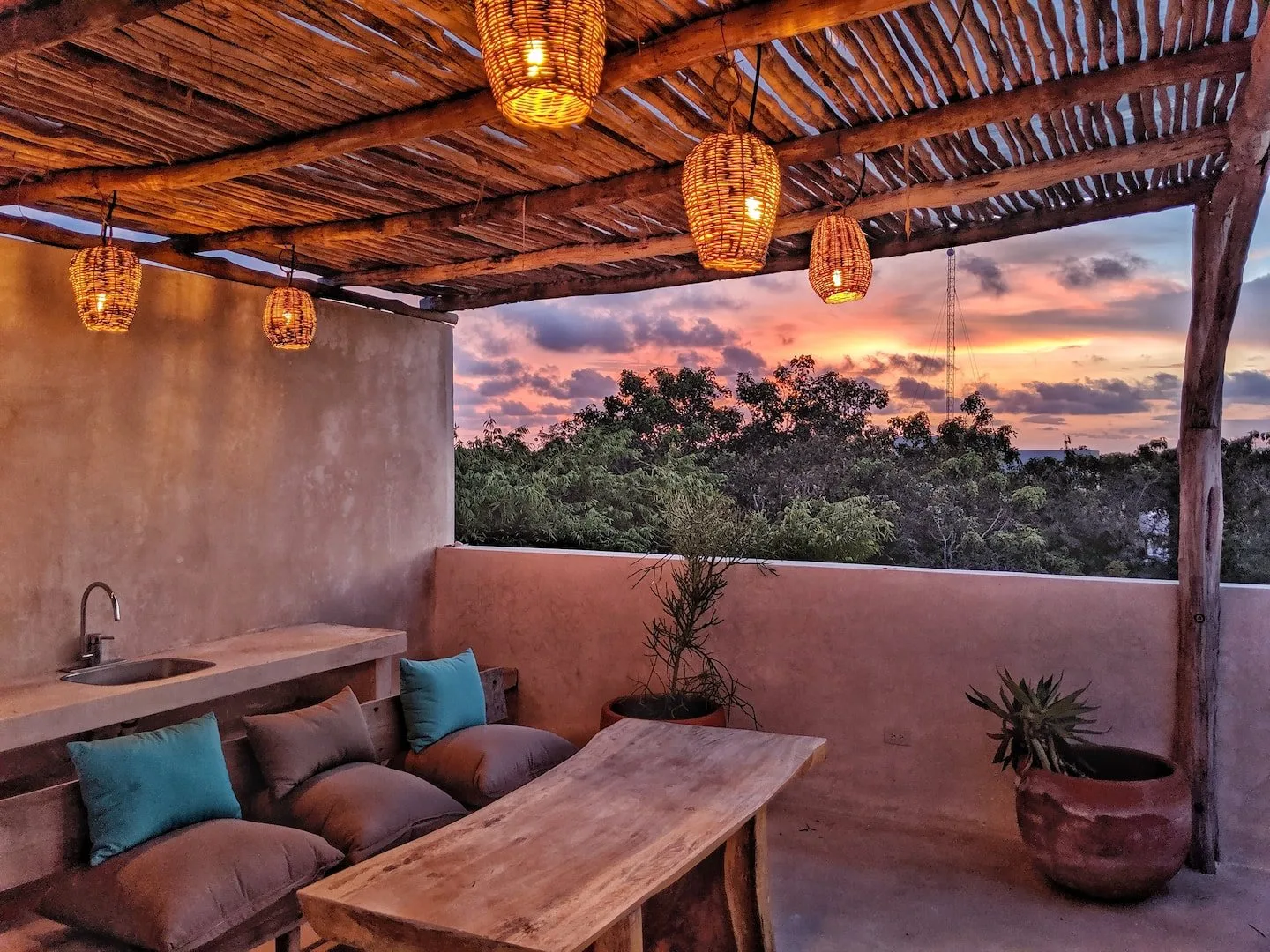 Un patio al aire libre con asientos acolchados y vista al atardecer.