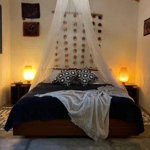 Espacio representativo del hotel: Un dormitorio centrado en una cama bajo un dosel de tela.