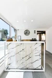 Representative hotel space: A bright reception area has a marble-patterned counter and large windows.