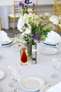 Representative hotel space: A dining table is set with white plates, glassware, and floral centerpieces.