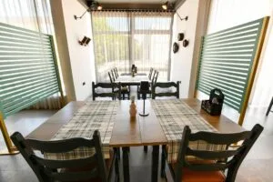 Representative hotel space: Dining room with a long table, chairs, and large windows.