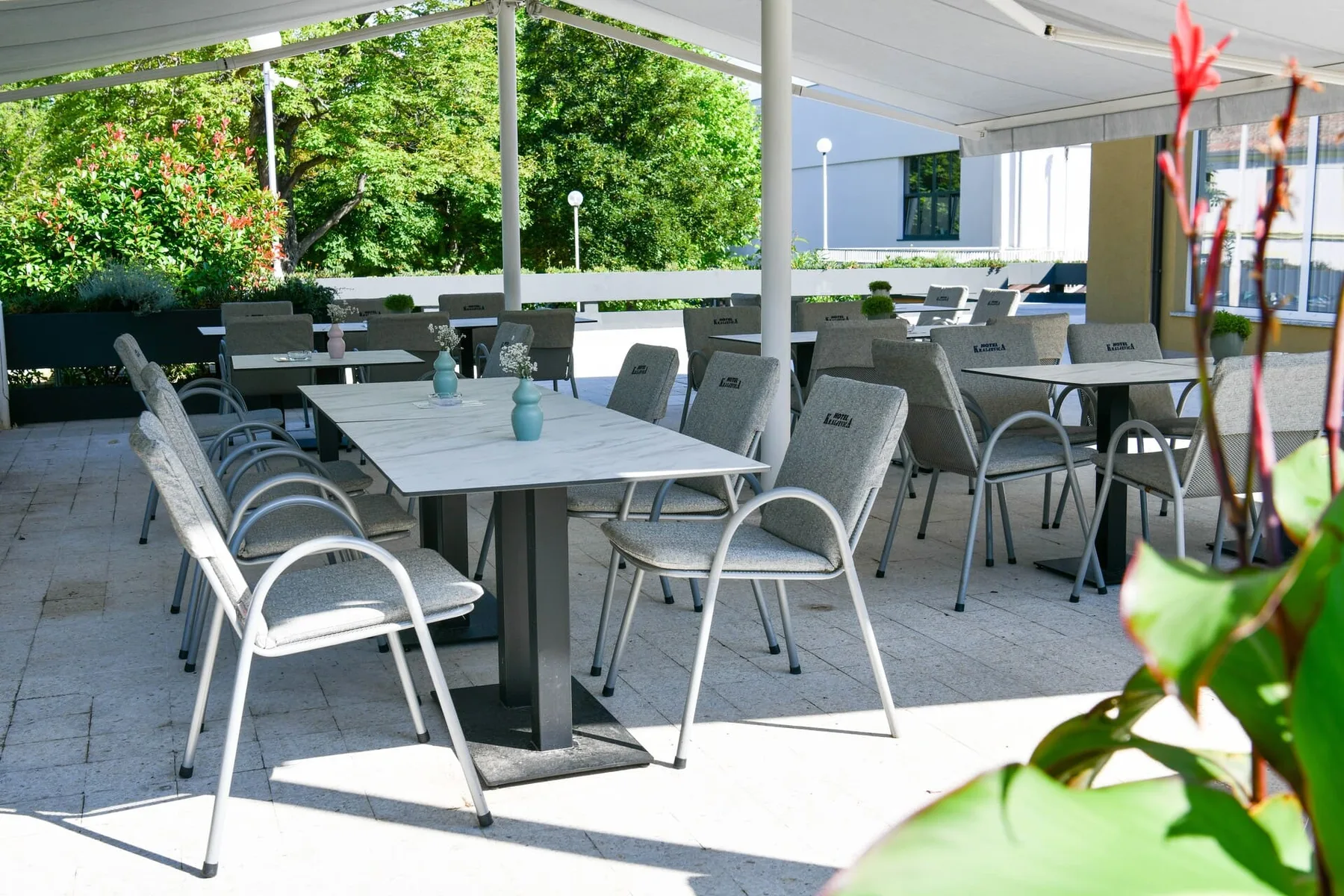 Representative hotel space: A covered outdoor seating area with tables and chairs.