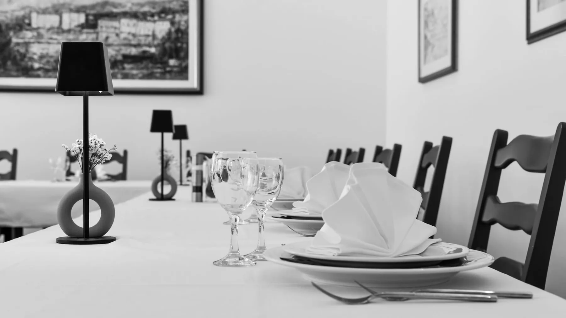 Representative hotel space: A dining room table is set with glassware, plates, and folded napkins.