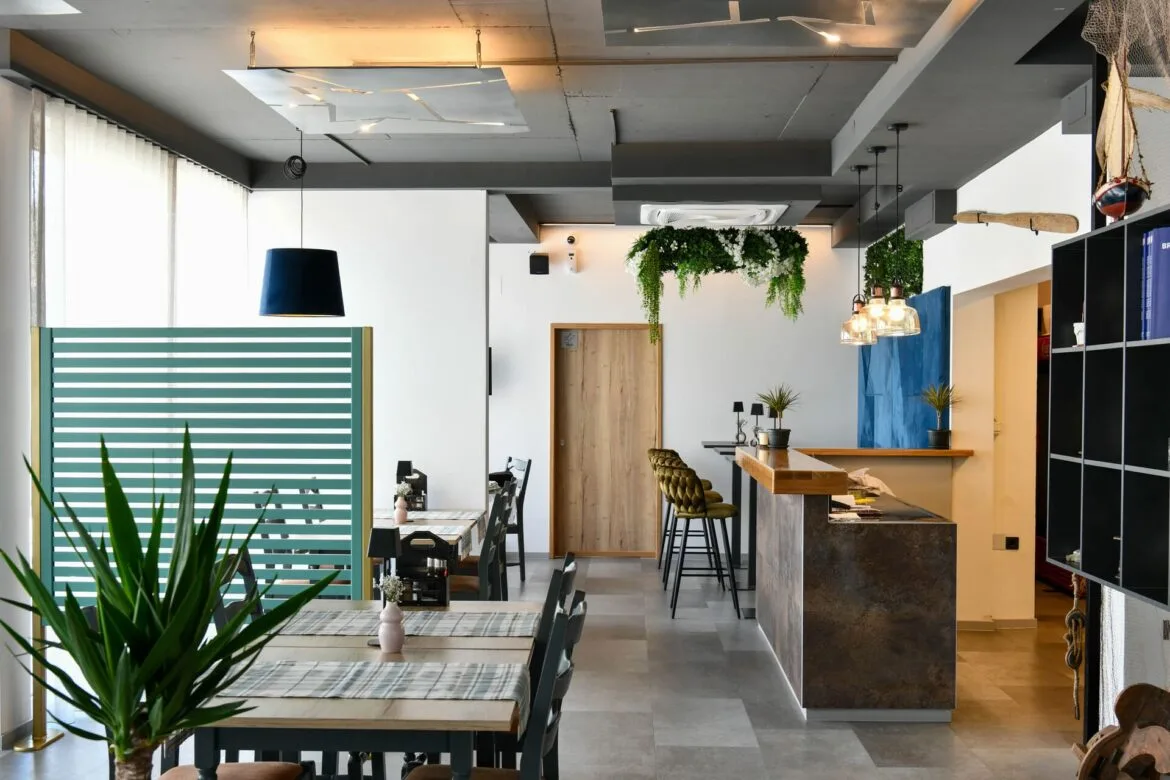 Representative hotel space: A modern dining and bar area with tables, stools, and hanging plants.