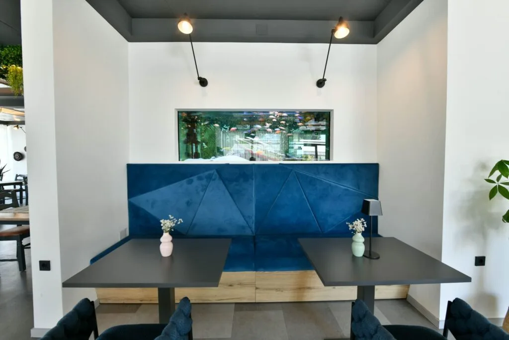 Representative hotel space: A modern hotel reception area has a blue front desk and two table lamps.