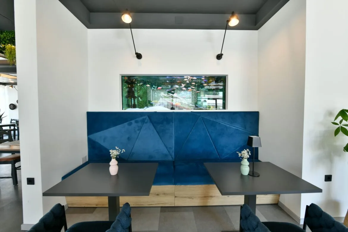 Representative hotel space: A modern lobby seating area features a blue upholstered bench and two tables.
