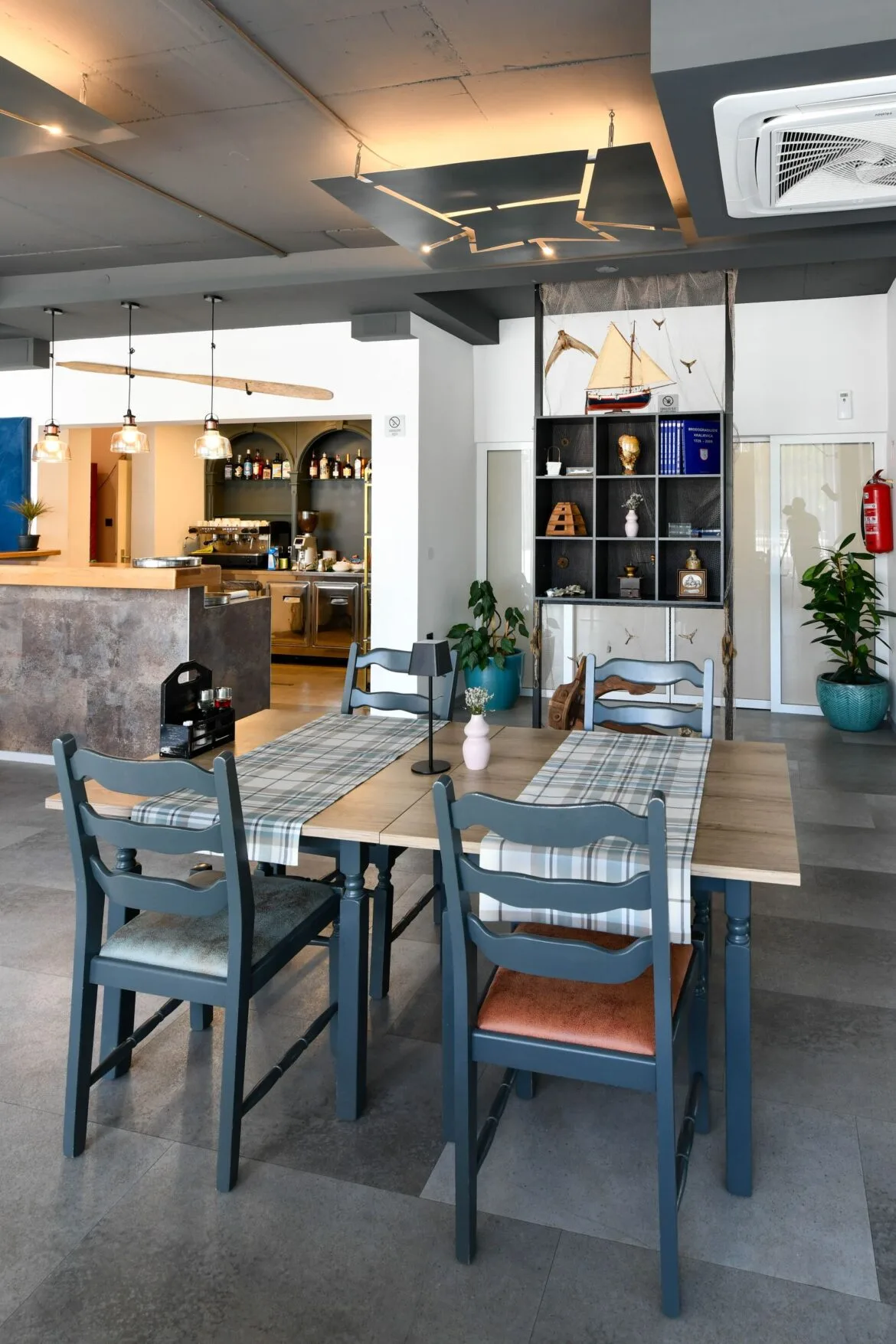 Representative hotel space: A dining area with tables and chairs beside a bar.