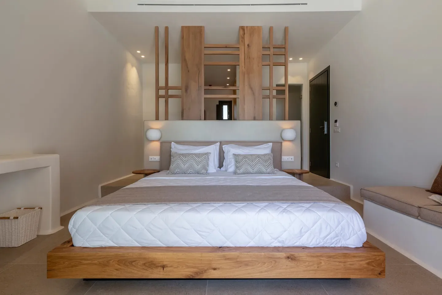 Un dormitorio con una cama bien hecha y un cabecero revestido de madera.