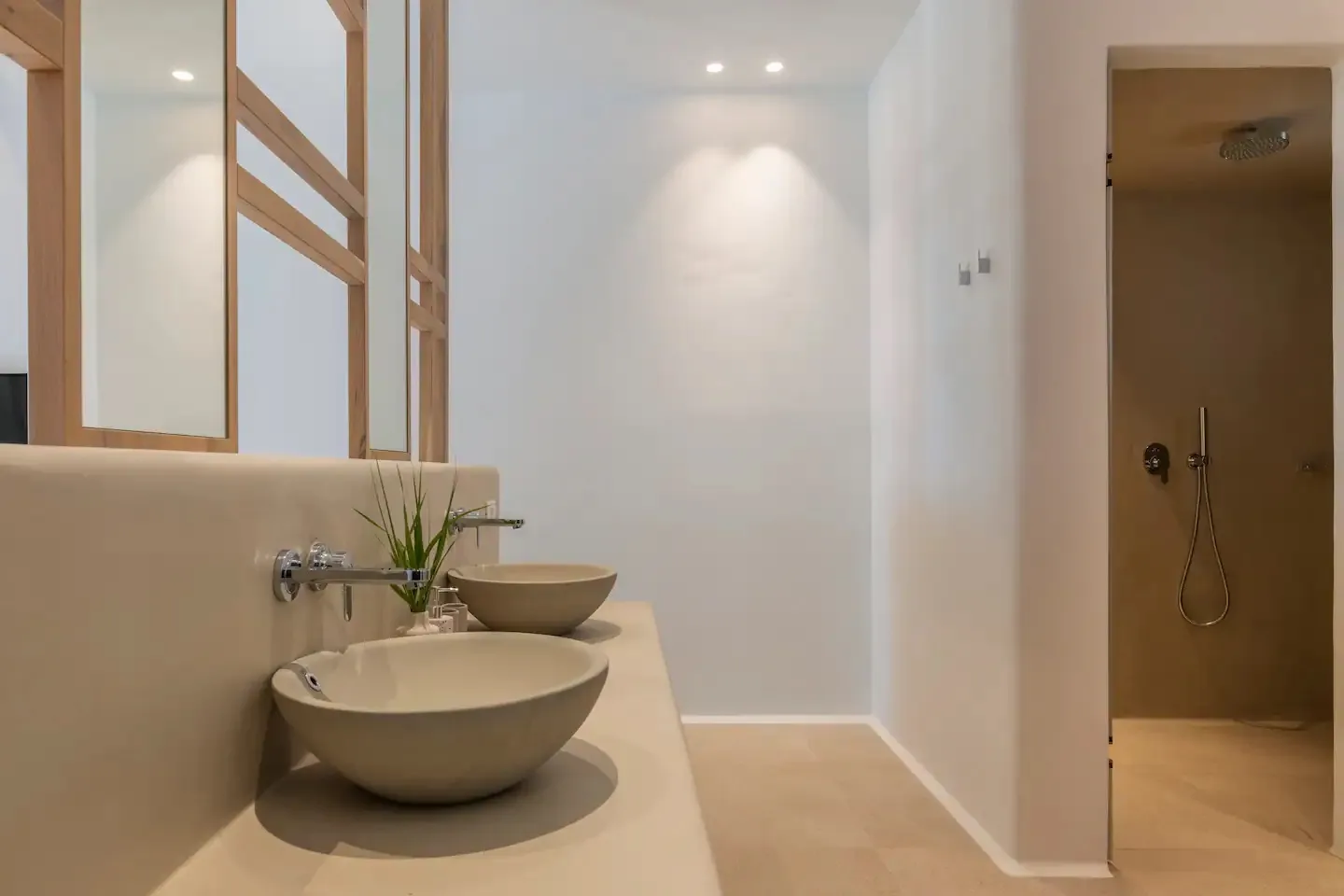 Un baño moderno con un lavabo sobre encimera y una zona de ducha abierta.