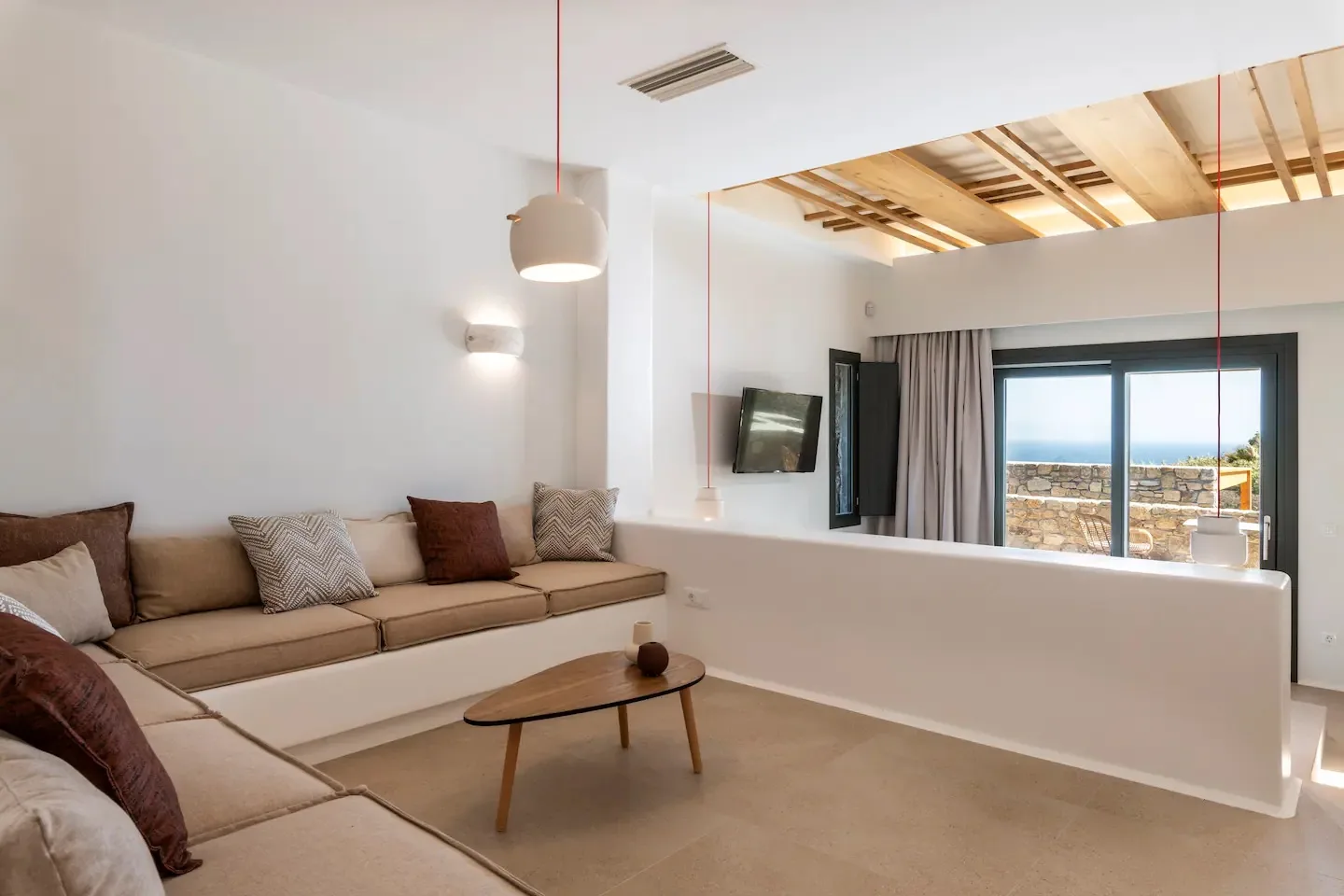 Una sala de estar con asientos y una ventana con vistas al mar.