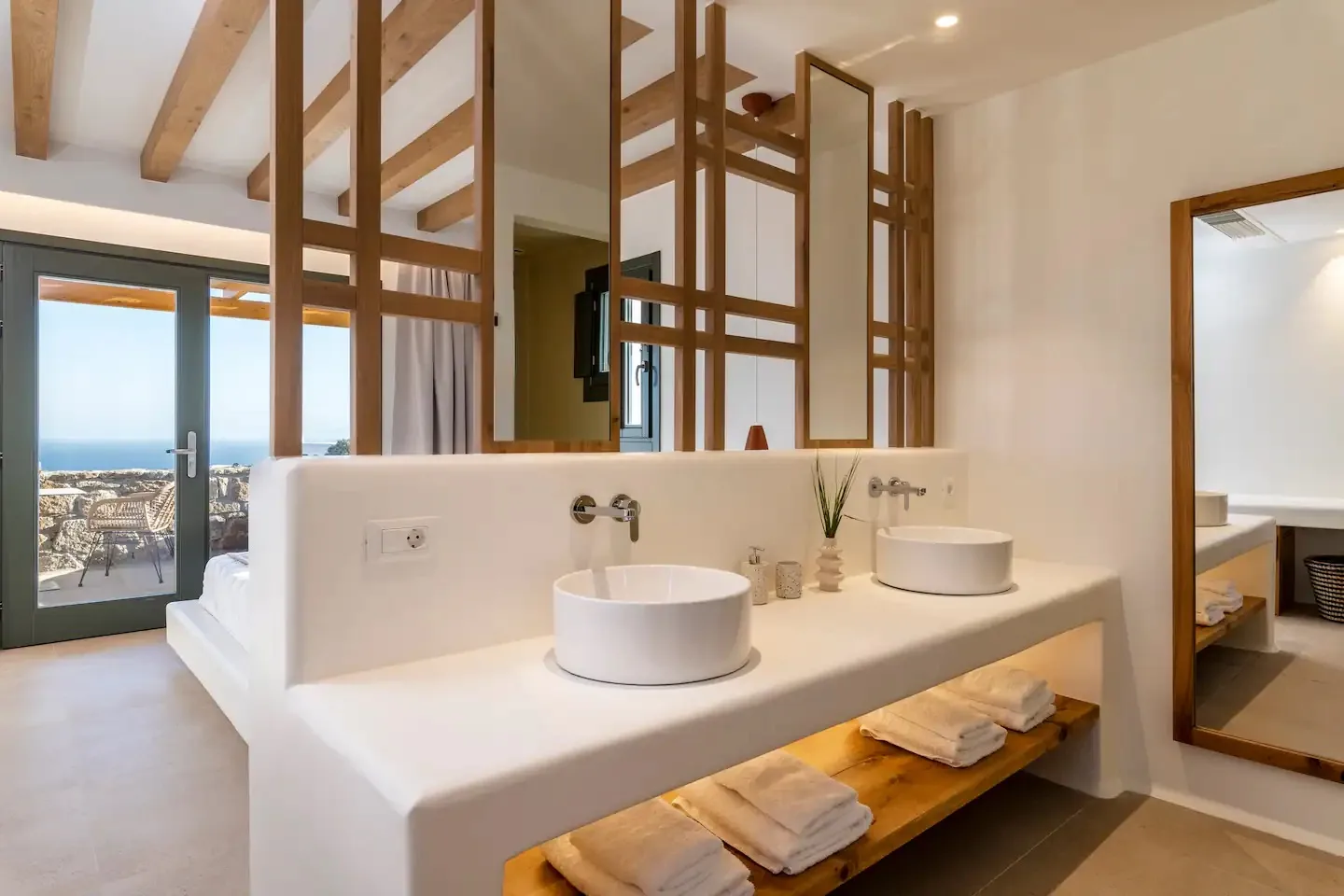 Un tocador de baño con dos lavabos está junto a una división de madera.