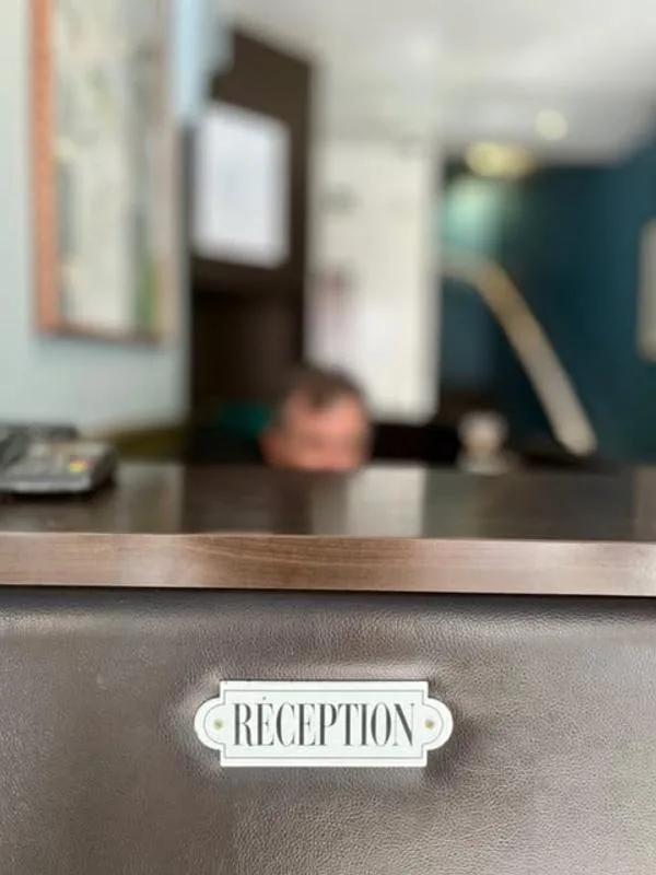 Representative hotel space: A reception desk with a sign faces a softly blurred lobby.