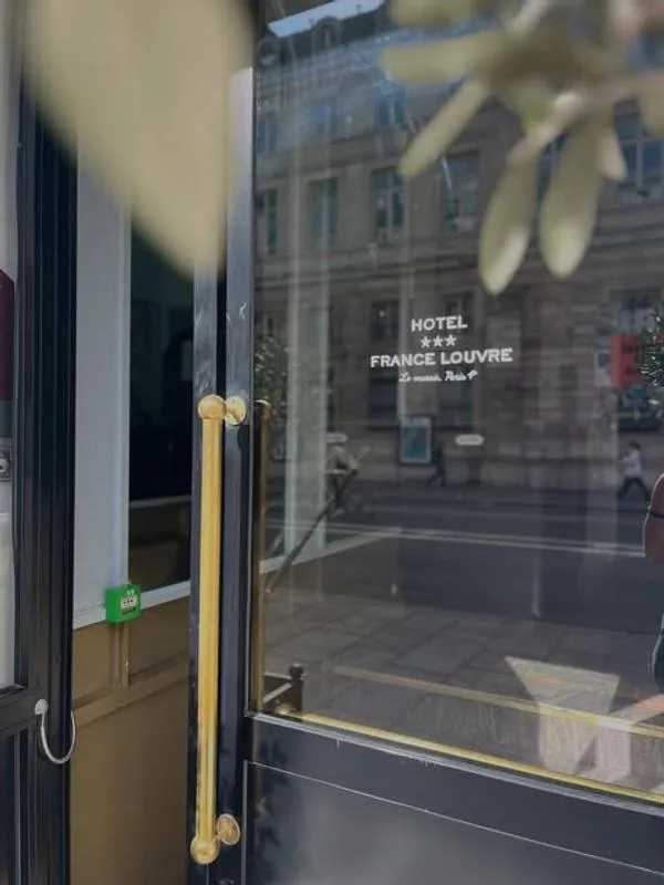 Representative hotel space: Glass hotel entrance doors show a street scene reflected in the glass.