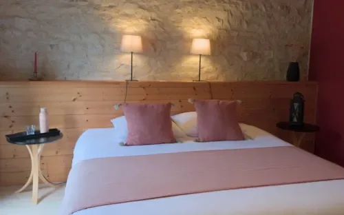Espacio representativo del hotel: Un dormitorio con una cama tendida y dos lámparas de pared.