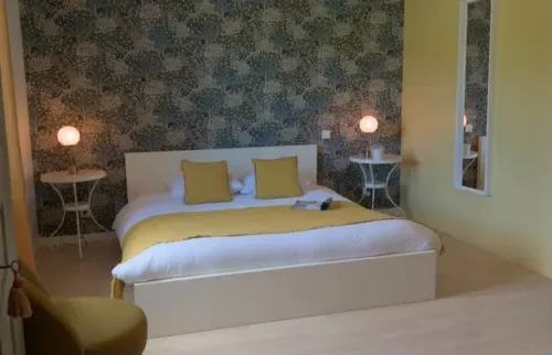 Espacio representativo del hotel: Un dormitorio con una cama bien hecha y lámparas a ambos lados.