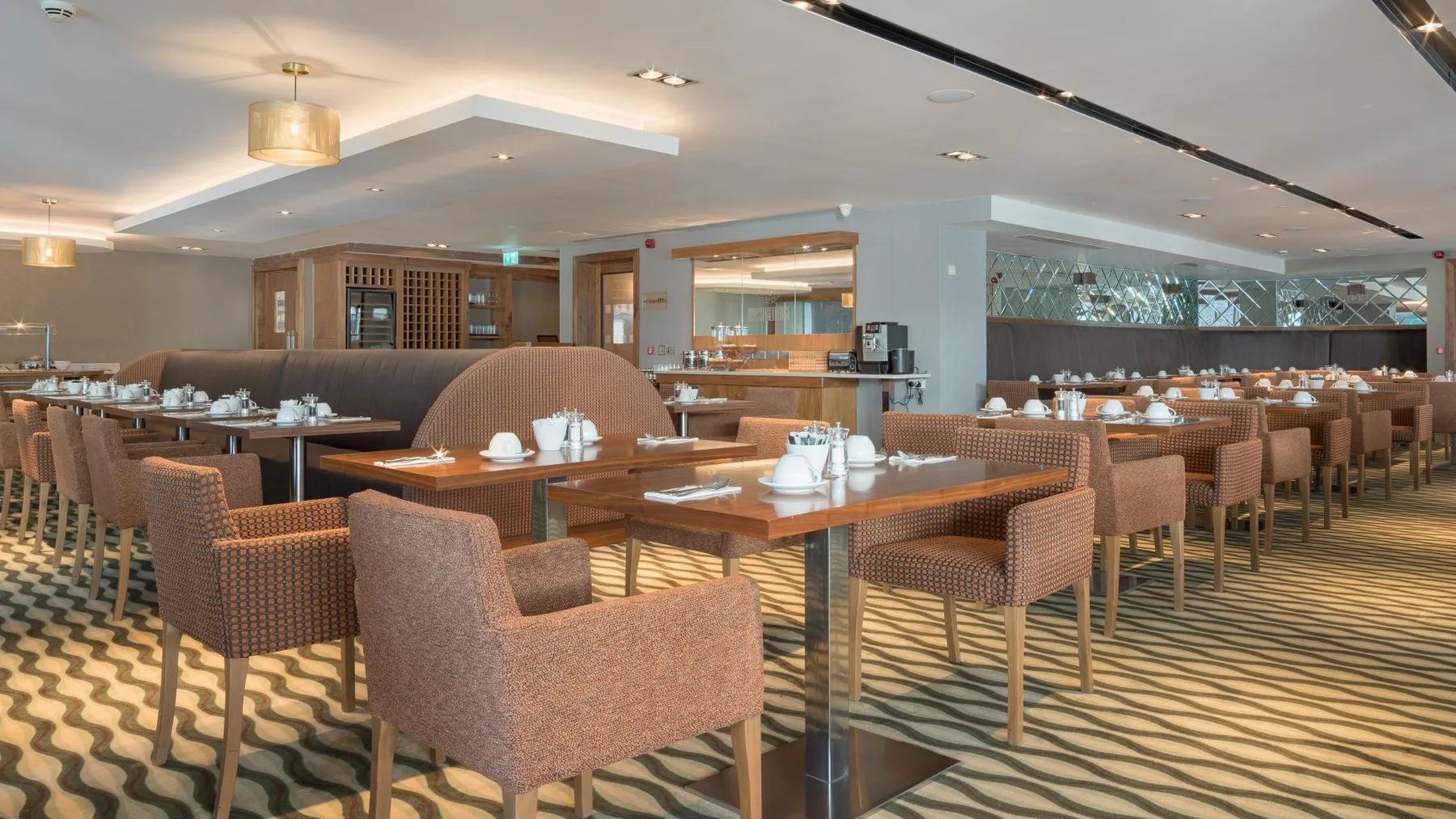 Representative hotel space: A dining room with rows of tables set with dishes and seating.
