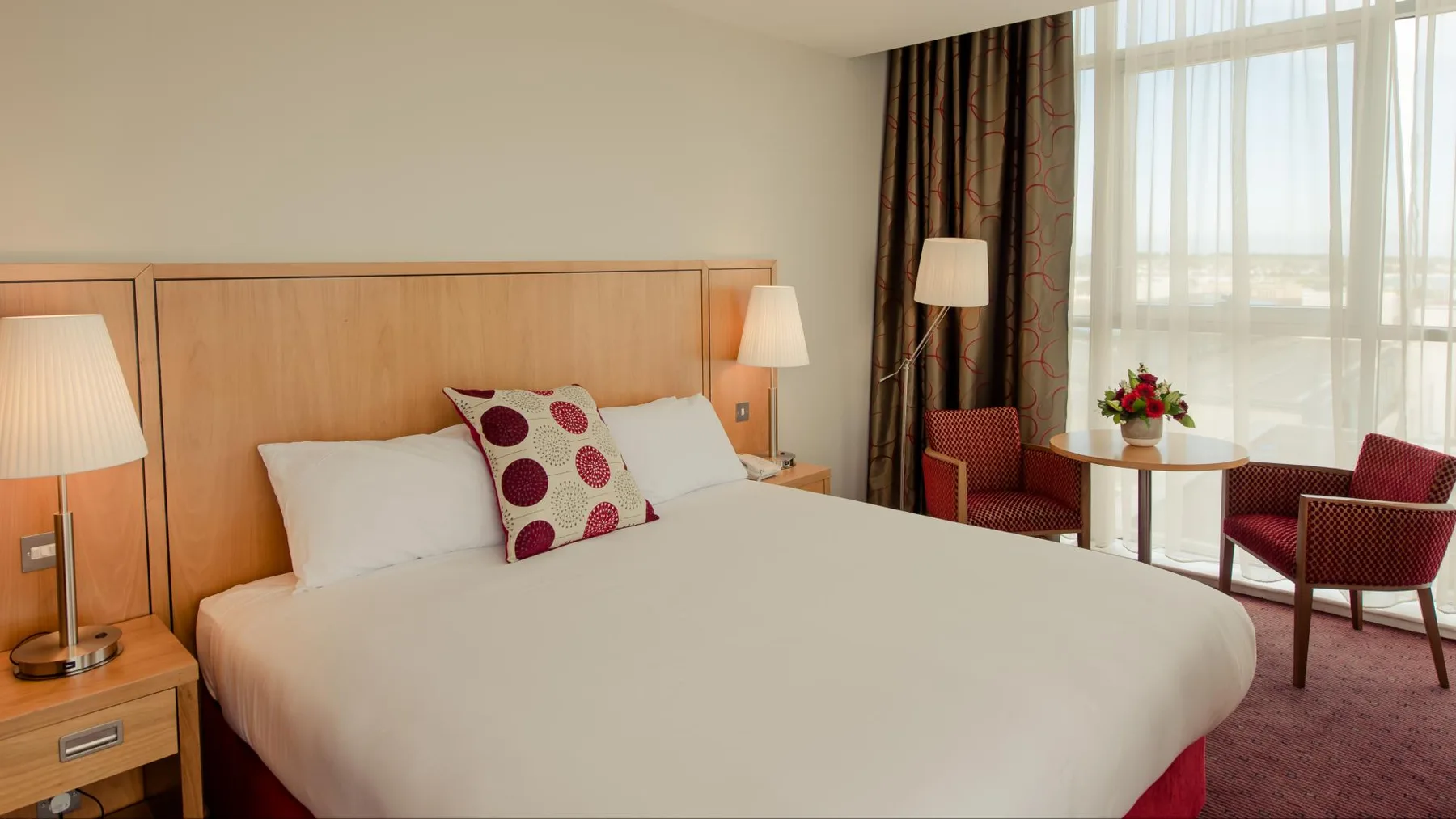 Representative hotel space: A hotel bedroom with a bed, bedside tables, and a seating area by the window.