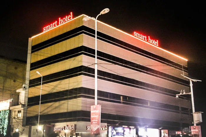 Espacio representativo del hotel: Un edificio hotelero de varias plantas con letreros iluminados por la noche.