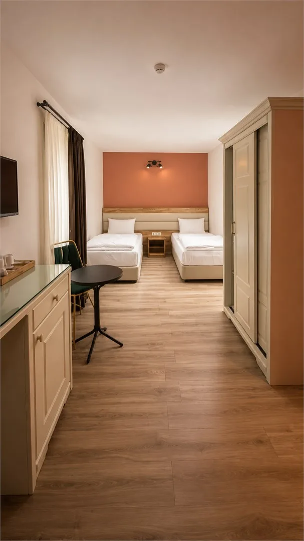 Espacio representativo del hotel: Un dormitorio de hotel con dos camas, una mesa de noche y un armario.
